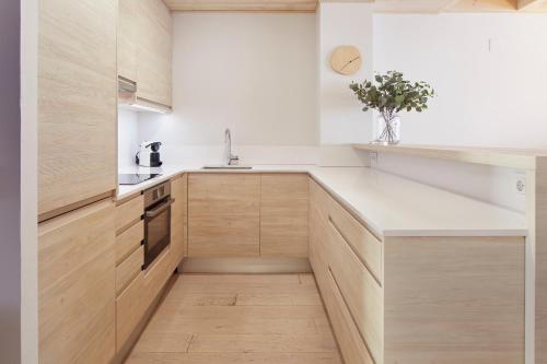 a kitchen with white counters and wooden cabinets at Casa Val de Ruda Luxe 71 by FeelFree Rentals in Naut Aran