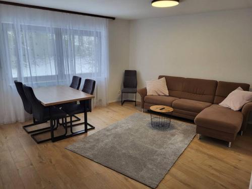 uma sala de estar com um sofá e uma mesa em Schönes Ruhiges Appartement em Crailsheim