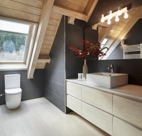 a bathroom with a toilet and a sink and a window at Casa Val de Ruda Luxe 71 by FeelFree Rentals in Naut Aran