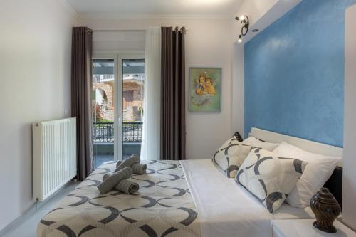 1 dormitorio con 1 cama grande y pared azul en Nina's Modern Apartment en Bastoúnion