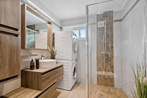 a bathroom with a sink and a washing machine at Hele Huset - Nært Oslo Lufthavn in Nannestad