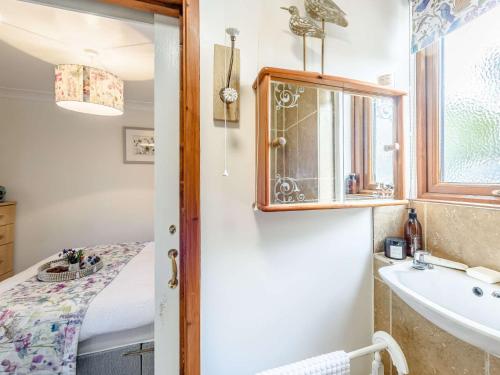 een badkamer met een wastafel en een spiegel bij 1 bed in Holywell 82277 in Whitford