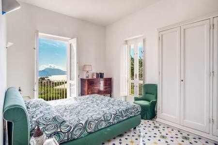a bedroom with a bed and a large window at Campanella Villas Gardens Pool Superview in Termini