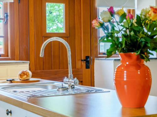 a kitchen sink with a vase of flowers on a counter at 2 bed in Nantyglo 82706 in Nantyglo