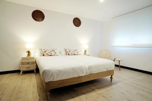 1 dormitorio con 1 cama con sábanas y almohadas blancas en La SIGRINA Tuy en Tui