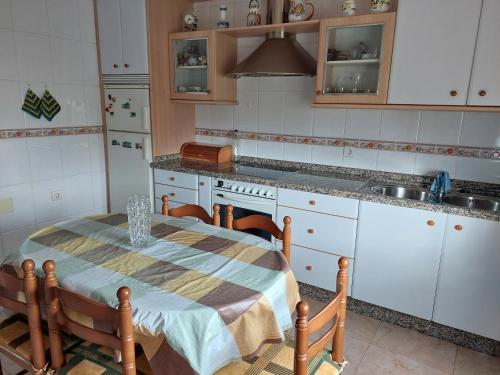 eine Küche mit einem Tisch mit Stühlen und einem Waschbecken in der Unterkunft Casa MaySa in Cacabelos