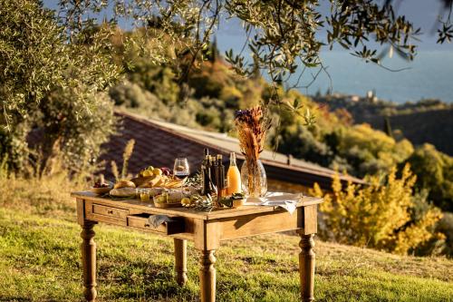 a table with food and bottles of wine on it at Colago Private Villas Lake Garda in Toscolano Maderno