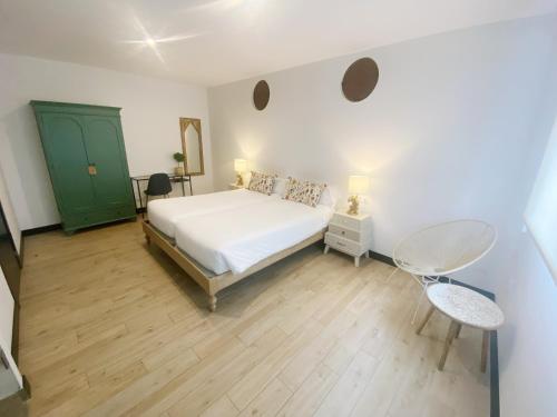 a bedroom with a white bed and a green door at La SIGRINA Tuy in Tui