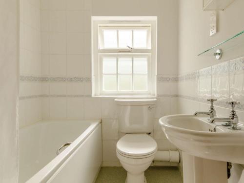 a white bathroom with a toilet and a sink at 3 Bed in Talybont-on-Usk BN351 in Talybont