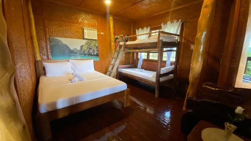 a bedroom with a bed and bunk beds in a room at CED Garden in El Nido