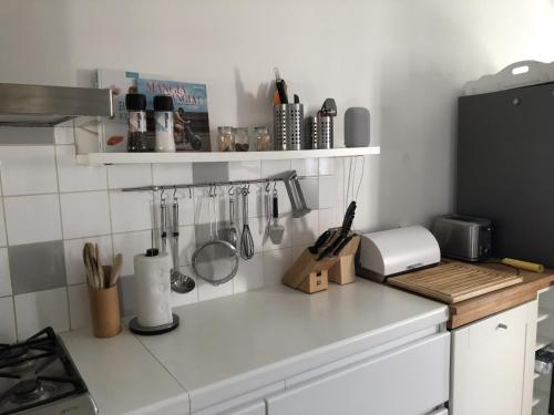 a kitchen counter with utensils on the wall at Begijnhof 13 Holiday Home in Zuienkerke