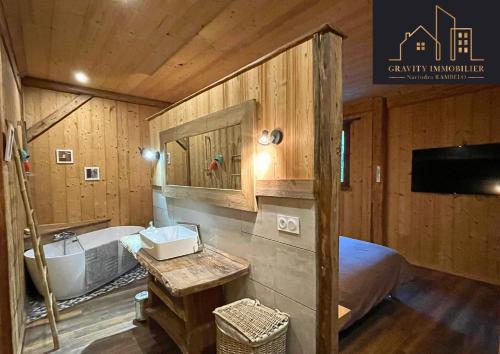 a bathroom with a bed and a sink and a tub at Luxueux chalet 5 chambres in Brizon