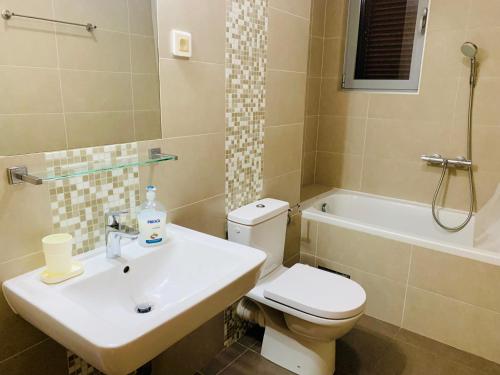 La salle de bains est pourvue de toilettes, d'un lavabo et d'une baignoire. dans l'établissement Lavender Bay Apartment F7, à Donji Morinj