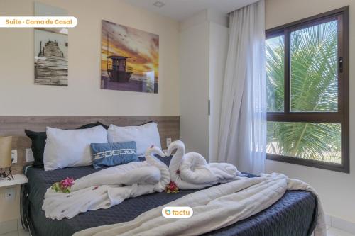 deux cygnes sont assis sur un lit avec des serviettes dans l'établissement Appartement compact à VG Sun Cumbuco par Tactu, à Paracumbuca