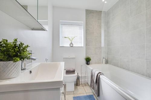 a bathroom with a tub and a toilet and a sink at Luxury 2-Bedroom Formby Property in Formby