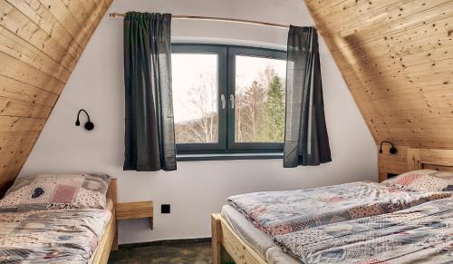 two beds in a room with a window at Resort Bobrovník in Lipova Lazne