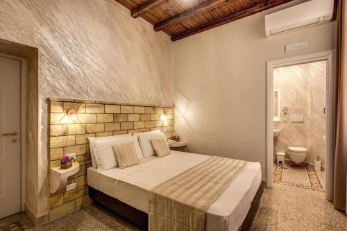 a bedroom with a large bed and a bathroom at Colosseo Accomodation Room Guest House in Rome