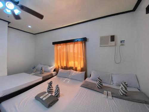 エルニドにあるMIA Affordable roomsのベッドが2つと窓のある部屋