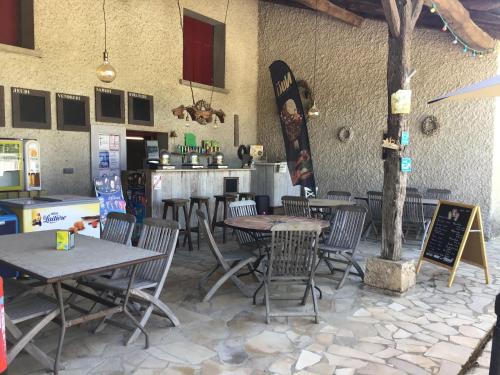 un restaurant avec des tables et des chaises et un bar dans l'établissement Camping Fargogne, à Puygaillard-de-Quercy