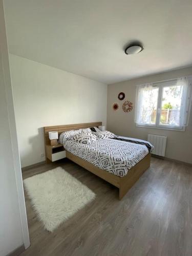 - une chambre avec un lit, une fenêtre et un tapis dans l'établissement Charmante Maison entre châteaux et océan, à Cussac-Fort-Medoc