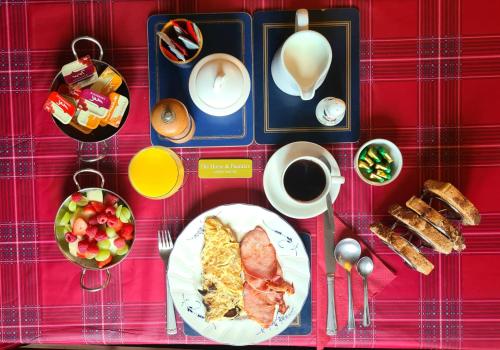 uma mesa com um prato de comida para o pequeno-almoço e uma chávena de café em The horse and panniers guest house. em North Luffenham