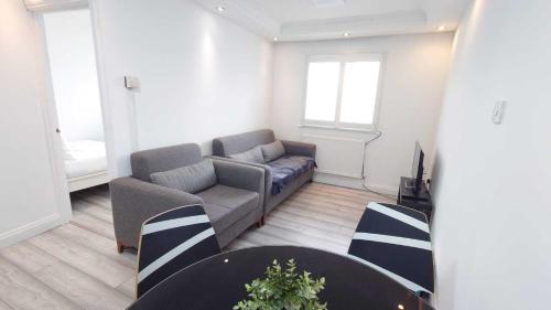 ein Wohnzimmer mit einem Sofa und einem Tisch in der Unterkunft Eurostar City Apartments in London