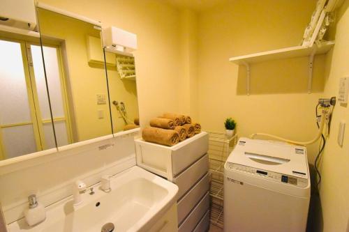 un bagno con lavandino e lavatrice di NEW!! 浅草 スカイツリー近く 貸切最大5人 東京観光に最適 無料WiFi a Tokyo