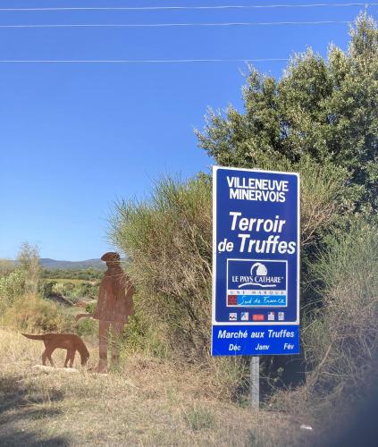 a man and a dog standing next to a sign at Chez Providence Chambres et Table d'Hôtes in Cuxac-Cabardès