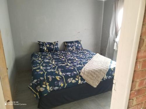 1 dormitorio con 1 cama con manta azul y almohadas en Airportview hieght, 