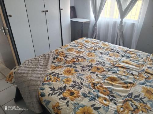 Una cama con edredón en un dormitorio en Airportview hieght, 