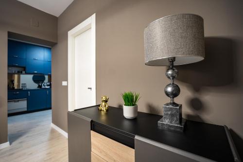 ein Raum mit einem Tisch mit einer Lampe darauf in der Unterkunft Blvd Ivory Pipera ap.70A in Bukarest