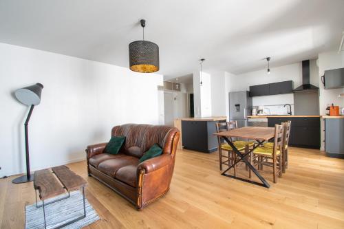 un salon avec un canapé et une table dans l'établissement Cosy T2 de 50 m² Centre-Ville avec Garage & Balcon, à Nantes