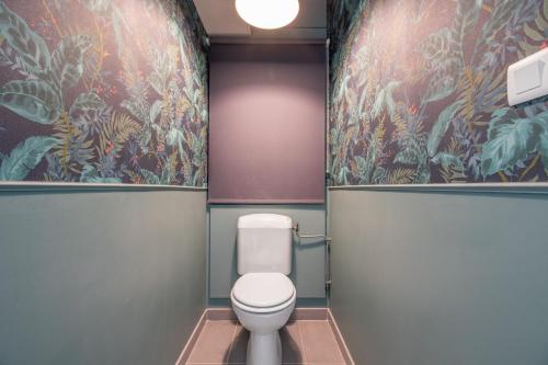 een badkamer met een toilet en bloemenbehang bij Cosy T2 de 50 m² Centre-Ville avec Garage & Balcon in Nantes