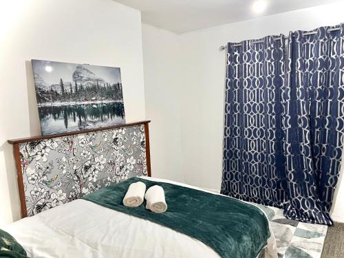 a bedroom with a bed with two white slippers on it at Cosy Home Stay in London