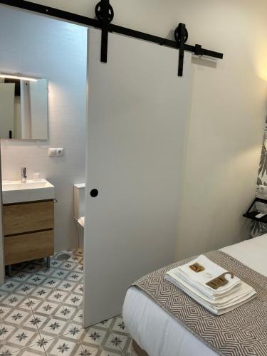 a bathroom with a bed and a sink and a door at EME SEVILLA TURISTICA in Seville