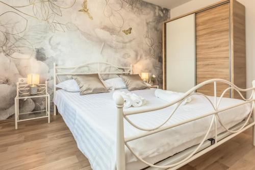 a bedroom with a white bed and a wall mural at Villa Patria with Media room, Private pool, Summer kitchen, Gym in Lovreć