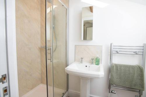 y baño con lavabo y ducha. en Gorgeous 2-bed Home in Lincoln by Renzo, Stunning Countryside Location, Free Parking!, en Stow