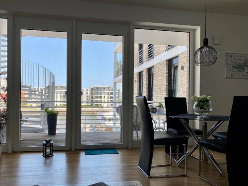 a dining room with sliding glass doors with a table and chairs at Bootshaus Am Neuen Hafen in Bremerhaven