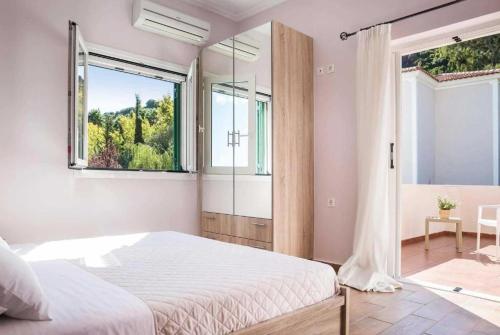 a bedroom with a large bed and a window at Villa Olga in Katelios