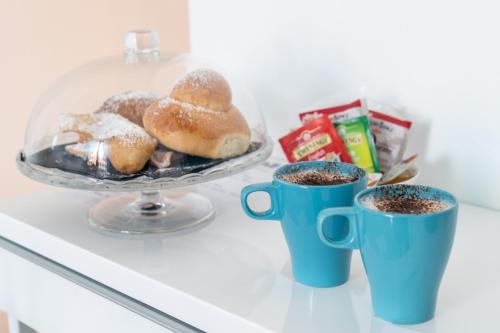 Un plateau de beignets et deux tasses de café sur un comptoir dans l'établissement President Plaza Vip Suite Spa by Babylon Stay, à Naples