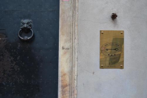 a door with a clock on the side of it at B&B Piccoli Leoni in Genova