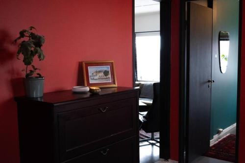 um quarto com uma cómoda e uma parede vermelha em Charming apartment in central Stavanger em Stavanger
