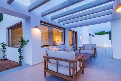a living room with a table and chairs at Can Lluc Suites & Villas Ibiza's Peaceful Getaway in Sant Rafael de Sa Creu