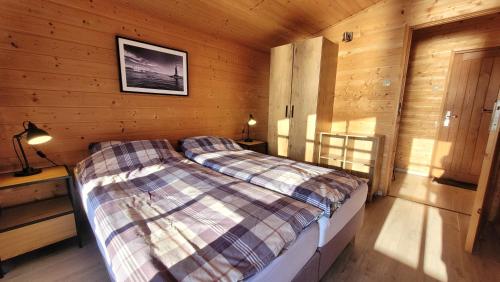 a bedroom with a bed in a wooden cabin at Piękny Brzeg in Węgorzewo