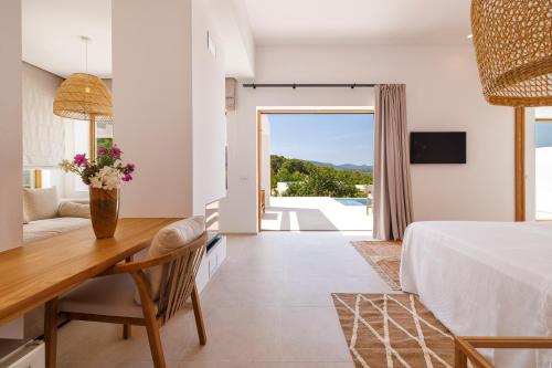 a bedroom with a bed and a desk with a table at Country Homes, Suites & Villas by Can LLuc in Sant Rafael de Sa Creu