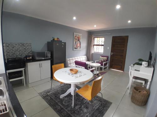 cocina y comedor con mesa y sillas en Be-My-Guest Holiday Apartment, en Maseru