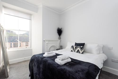 Un dormitorio blanco con una cama con toallas. en Spectacular View City Centre Haven en Edimburgo