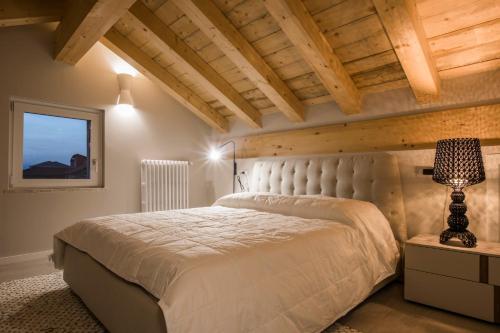 una camera con un grande letto in una stanza con soffitti in legno di Le Tre Sorelle a Il Guasto