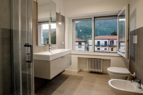 een badkamer met een wastafel, een toilet en een raam bij Le Tre Sorelle in Il Guasto