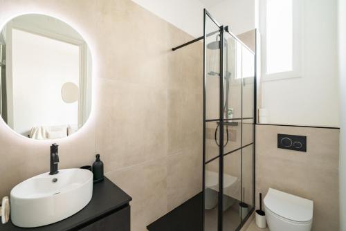 une salle de bain avec un lavabo et un miroir dans l'établissement Hypercentre - Palais - Croisette - Plage - BF, à Cannes